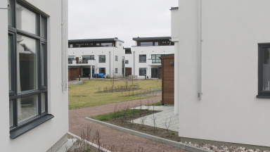 Hus med vit fasad och innegård