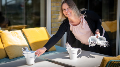 Katja Jakobson ställer fram tillbringare med bestick på bord